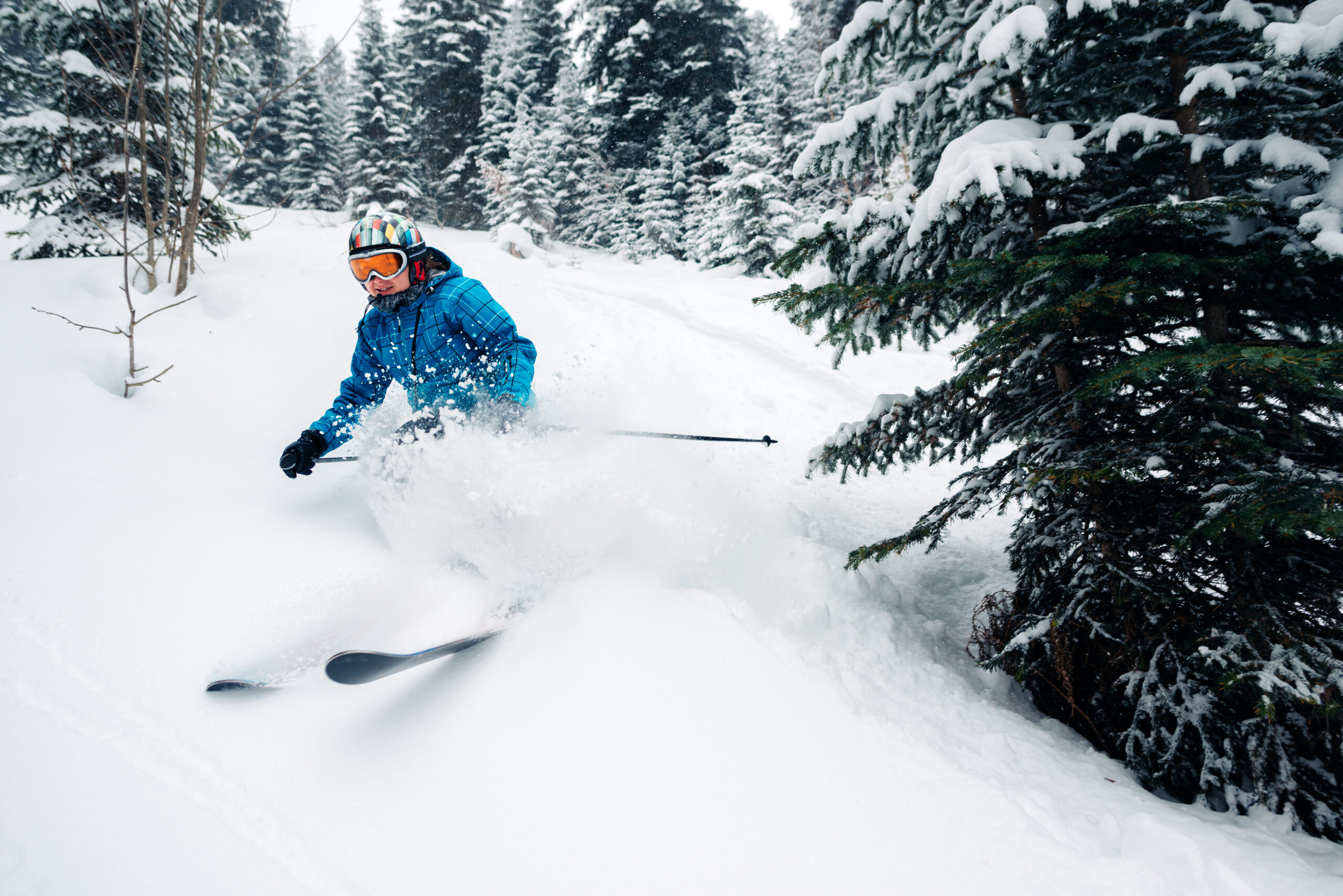 skier riding through deep snow getting a face shot