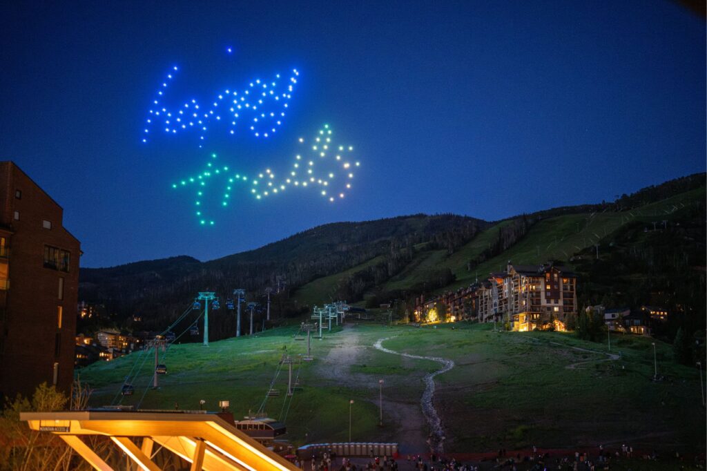 steamboat forth of july with drones in the sky spelling out happy trails.