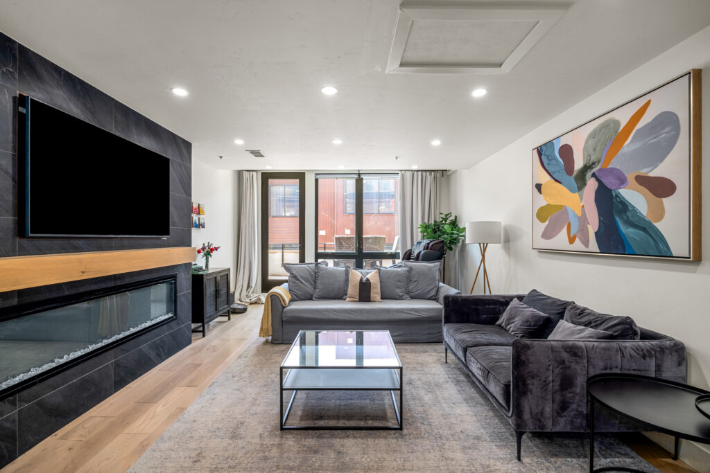 upscale living room with flat screen tv, gas fireplace. couches and coffee table